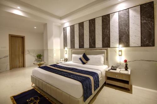 ニューデリーにあるHotel Delhi 37 by Star Group NEAR DELHI AIRPORTのベッドルーム1室(大型ベッド1台、青と白の毛布付)