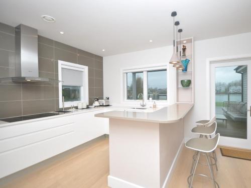 uma cozinha com balcões brancos, um lavatório e janelas em 4 bed in South Cerney 72676 em South Cerney