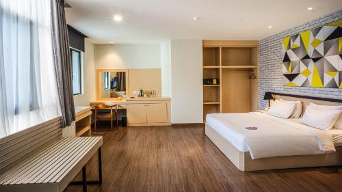 - une chambre avec un lit et un banc dans l'établissement Nite & Day Laguna Bintan, à Tanjung Pinang