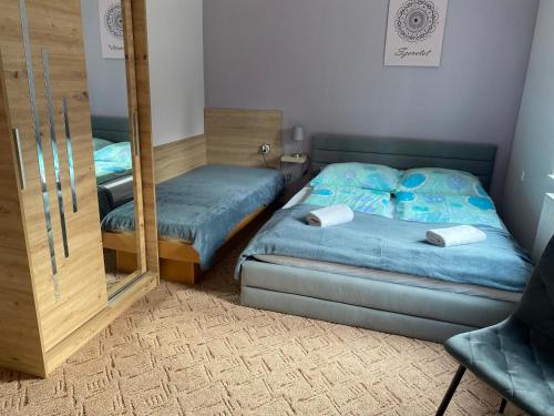 1 dormitorio con 2 camas individuales y espejo en Bakonyi Mandala Ház, en Bakonybél