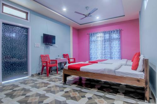 Schlafzimmer mit einem Bett, einem Tisch und Stühlen in der Unterkunft OYO Flagship Bonfire Kaziranga Resort in Kāziranga