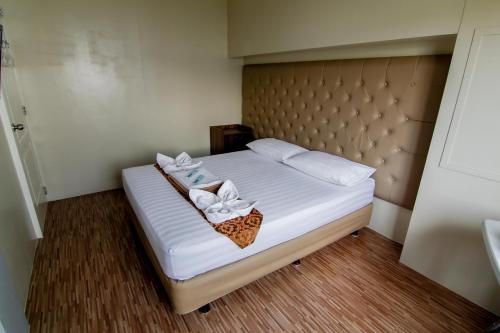 a bedroom with a bed with white towels on it at DG Budget Hotel Salem in Manila