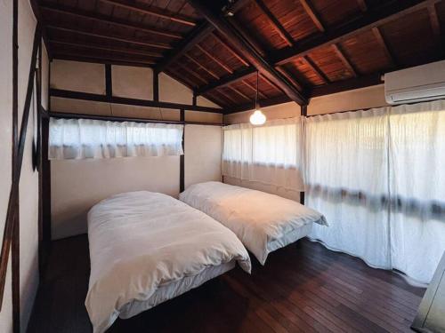 1 dormitorio con 2 camas en una habitación en ひねもす102:宇野駅から車で5分 直島へ 最大8名様 古民家 en Tamano