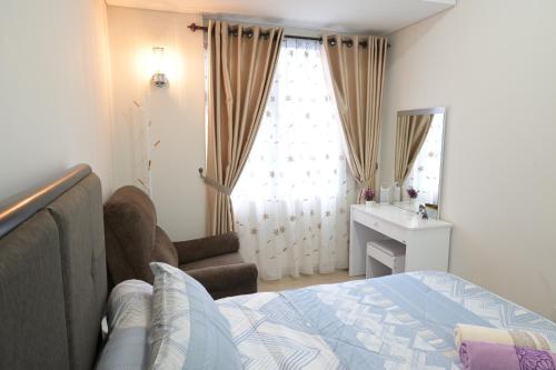 a bedroom with a bed and a desk and a window at Apartment Medan Podomoro City Deli by OLS Studio in Medan