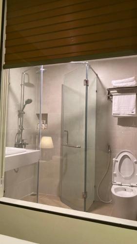 a bathroom with a shower with a toilet and a sink at Dongvan Ville Du H'Mong Hotel in Dồng Văn