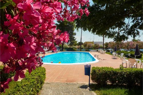 ein Schwimmbad in einem Park mit rosa Blumen in der Unterkunft Villetta Relax With Pool in Residence - Happy Rentals in Melendugno
