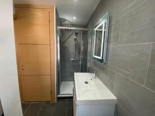 La salle de bains est pourvue d'un lavabo blanc et d'une douche. dans l'établissement NEW! Brand New Beautiful Modern Apartment, à Londres