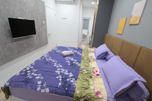 a bedroom with a bed with a purple comforter at Apartment Medan Podomoro City Deli by OLS Studio in Medan