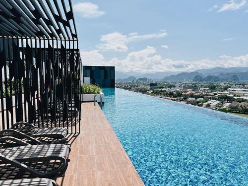 a infinity pool with lounge chairs on a building at DnQ Homestay at The Horizon with Netflix, LG Purifier,Wifi in the Centre of Ipoh in Ipoh