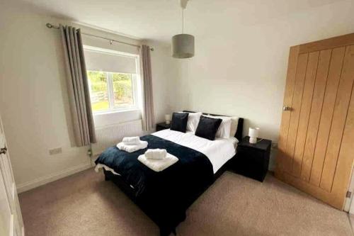 a bedroom with a large bed with towels on it at ERIN NEAMH - Magnificent sea views cosy cottage in Cumbria 