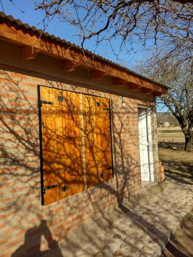 un edificio de ladrillo con una gran puerta de madera en Cabañas La Peperina in 