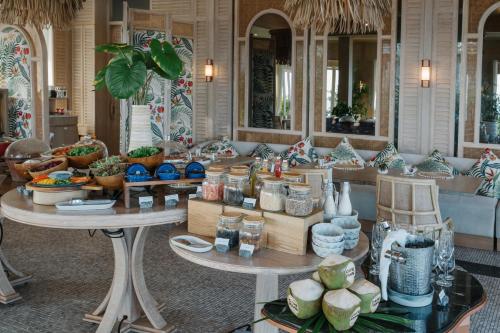 a room with two tables filled with differentiatesiatesiatesiatesiatesiatesktop at Cape Fahn Hotel - Private Islands Samui in Choeng Mon Beach