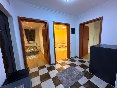 a living room with a checkerboard floor and two doors at 38 Apartment 2 in Pristina