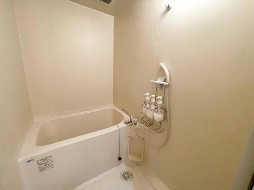 a white bathroom with a tub and a sink at TasoneStayOsaka なんば大国大山302 in Osaka