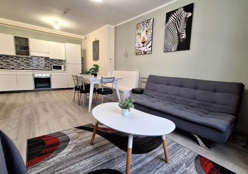 Al Glicine Apartments في لازيسي: غرفة معيشة بها أريكة وطاولة