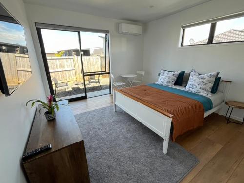 a bedroom with a bed and a large window at Ohana in Whitianga