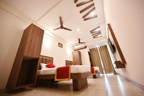 DharmastalaHotel Rays Inn Boarding & Lodging的卧室里有一张床和一台电视机