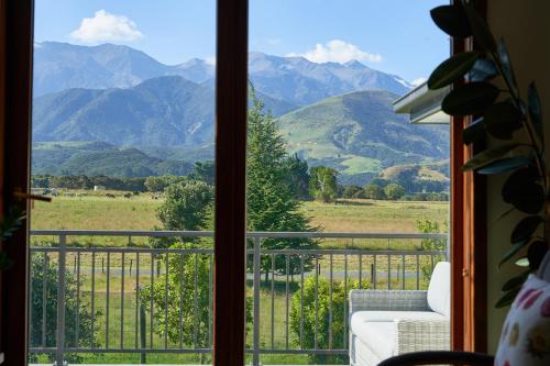 a view of a mountain range from a window at Kaikoura Mountain Views Villa in Kaikoura