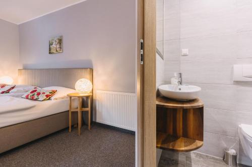 a bedroom with a bed and a sink and a tub at Karczma Taberska in Kolesin