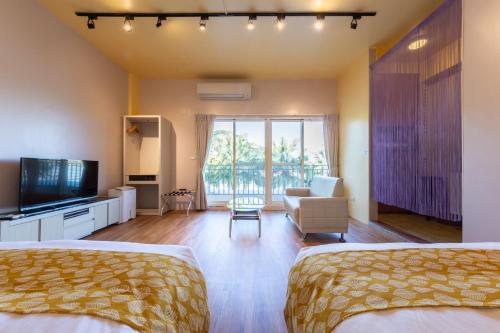 a hotel room with two beds and a television at 光腳丫宜蘭民宿 in Dongshan