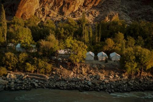 an aerial view of a group of tents next to a river at ARYA NATURE CAMP in Dah