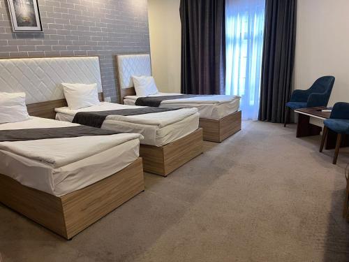 a hospital room with three beds and a table and chairs at Noor hotel in Baku