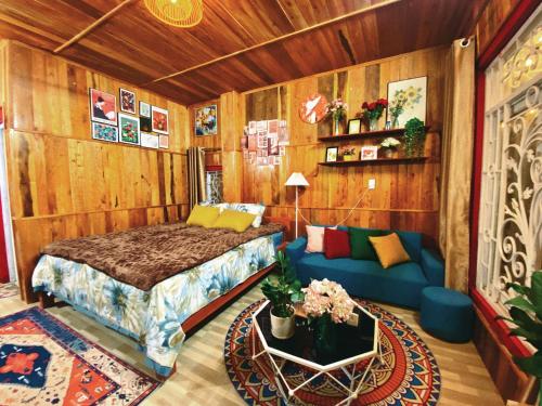a bedroom with a bed and a couch in a room at WIND HILL HOMESTAY HÀ GIANG in Làng Me