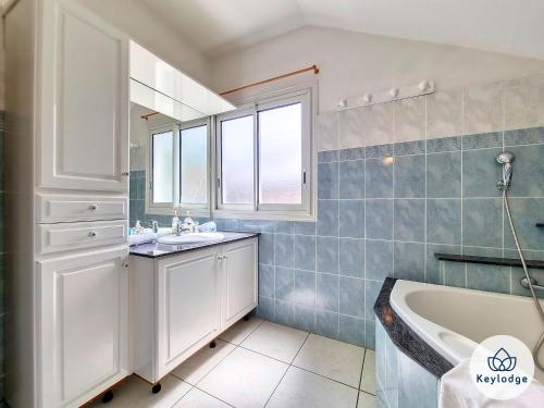 a bathroom with a sink and a tub and a window at Villa Aldabra - 3 etoiles avec piscine à Saint-Leu in Saint-Leu