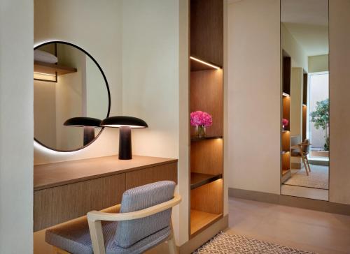 a room with a chair and a mirror at The Ritz-Carlton Ras Al Khaimah, Al Wadi Desert in Ras al Khaimah