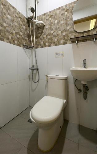 a bathroom with a toilet and a sink at Freemont Place in Manila