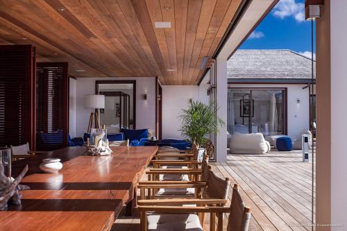 une salle à manger avec une grande table et des chaises en bois dans l'établissement Luxury Vacation Villa 3, à Gustavia
