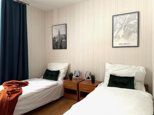 a room with two beds and a nightstand between them at Ponikiew Resort in Wadowice