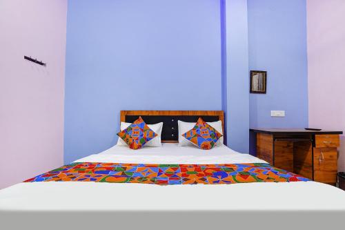 1 dormitorio azul con 1 cama con almohadas coloridas en FabExpress Evaan Deluxe Rooms, en Nagpur