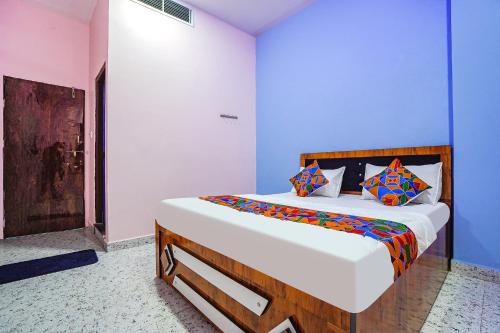 1 dormitorio con 1 cama grande y almohadas coloridas en FabExpress Evaan Deluxe Rooms, en Nagpur