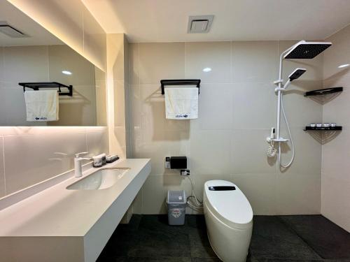 a white bathroom with a sink and a toilet at LuckyTito Dmall Boracay in Boracay