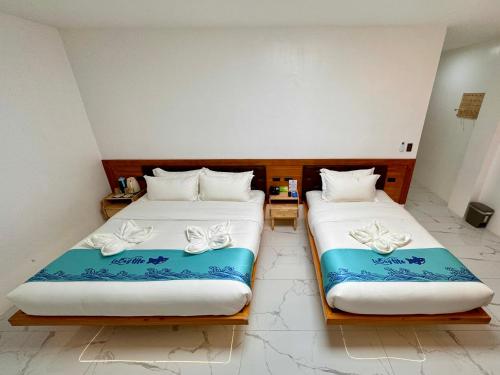 two beds sitting next to each other in a room at Lighthouse Inn Corporation former Lucky Tito Dmall Boracay in Boracay
