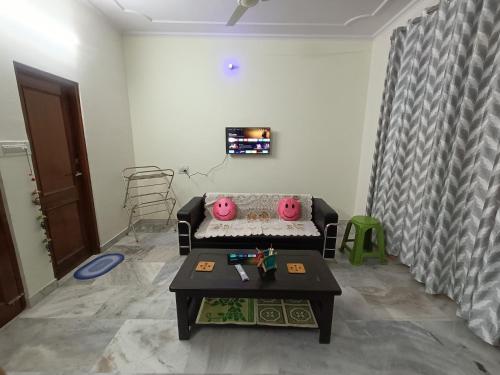 ein Wohnzimmer mit einem Sofa und einem Tisch in der Unterkunft Hotel angels paradise in Jaipur