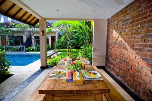 een tafel met eten naast een stenen muur bij Villa Cokelat in Canggu