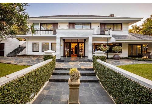 une maison blanche avec un escalier en face de celle-ci dans l'établissement Sheppard Boutique Hotel, à Nelspruit