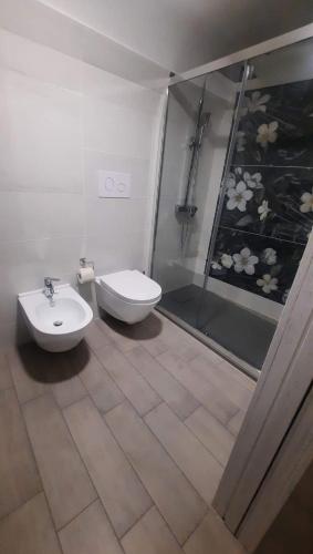 a bathroom with a toilet and a sink and a shower at Casa MaLù 15 Cin I T 0 7 1 0 3 3 B 4 0 0 0 8 8 3 3 2 in Monte SantʼAngelo