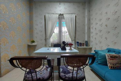 sala de estar con mesa, sillas y sofá en R Residence, en Medan