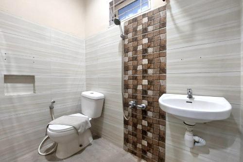 La salle de bains est pourvue de toilettes et d'un lavabo. dans l'établissement R Residence, à Medan