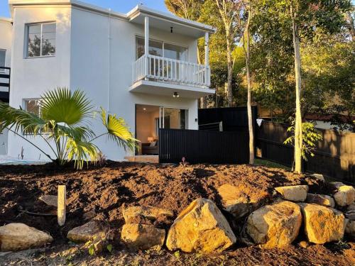 a white house with a yard with rocks at Location Location, sunshine beach, 100 m to beach( HA3) in Sunshine Beach