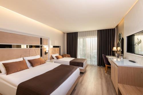 a hotel room with two beds and a desk at Swandor Hotels & Resorts - Topkapi Palace in Lara