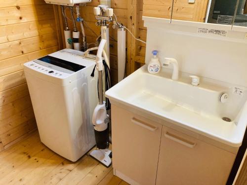 y baño con lavabo y lavadora. en Shirakaba no mori Cottage - Vacation STAY 55195v, en Abashiri