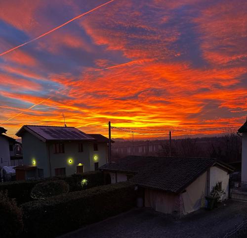 a sunset over houses with a red and orange sky at Il Fienile in Magliano Alpi