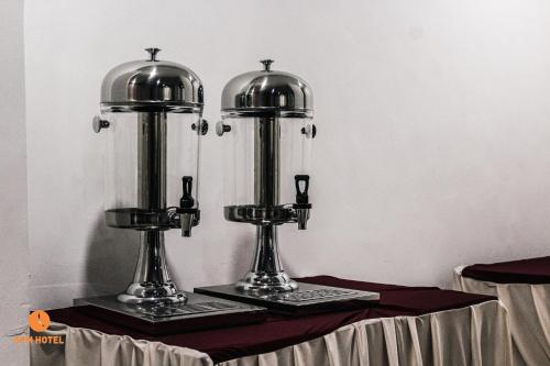 ein Tisch mit zwei Silbertrophäen darüber in der Unterkunft 5 PM Hotel in Nairobi