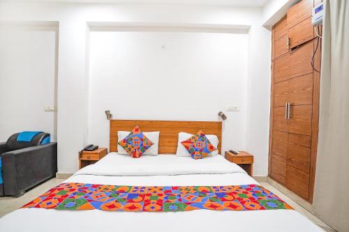 a bedroom with a bed with a colorful blanket on it at FabHotel Prime Residency in New Delhi