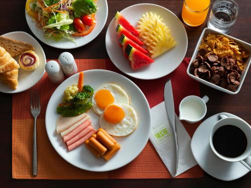 Ibis Phuket Patong في شاطيء باتونغ: طاولة مع أطباق من طعام الإفطار وكوب من القهوة