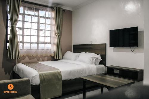 ein Hotelzimmer mit einem Bett und einem Fernseher in der Unterkunft 5 PM Hotel in Nairobi